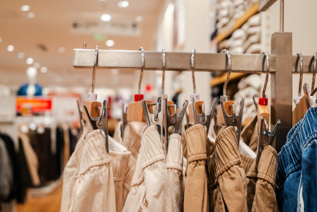 Detail shot of trousers on hangers in a clothing store, highlighting fashion trends.